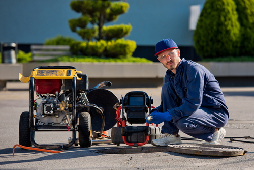 plumber with portable camera for pipe inspection